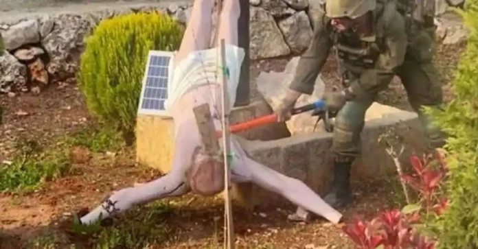 An Israeli soldier is seen smashing a statue of Jesus Christ in southern Lebanon with a sledgehammer. (Photo : Facebook/Addis Standard)