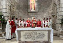 St. James Vicariate Marks 70 Years in Jerusalem Amid Faith, Memory, and Challenge Catholic Mass scene with priests in red and white vestments around a decorated altar, candles lit, in a stone chapel.