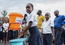 Ebola Outbreak in Central Africa Faces Prolonged Battle Amid Conflict, Misinformation, and Resource Shortages Children in the DRC wash their hands before going to class. In 2019, handwashing kits were distributed to schools in order to prevent the spread of Ebola. (Credit CRS)