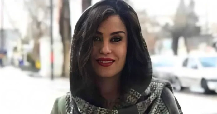 ۴۴۴_WVZp__v1308x687__box_0,0,1185,622 Woman with dark hair and red lipstick smiling at the camera on a city street.