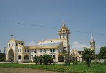 Cathedral’s Return Signals Fragile Hope Amid Myanmar’s Displacement Crisis Large ornate church with white and gold exterior, arched windows, and a tall bell tower under a clear blue sky.