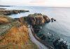 Aberdeen Bishop Expands Traditional Latin Mass Access as Illicit Episcopal Consecration Looms in Scotland Coastal cliffs with a castle perched on a rocky headland overlooking the sea at sunset contrasted with warm earth tones and calm water edge nearby